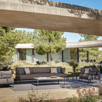 Modern outdoor furniture set in gray with soft blue and cream cushions, featuring sleek lines and minimalist design.