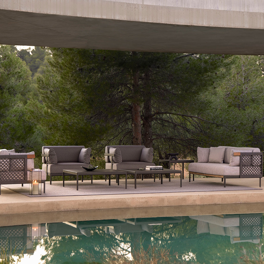 Modern outdoor furniture in gray tones with sleek lines, featuring a textured pattern and minimalist design.