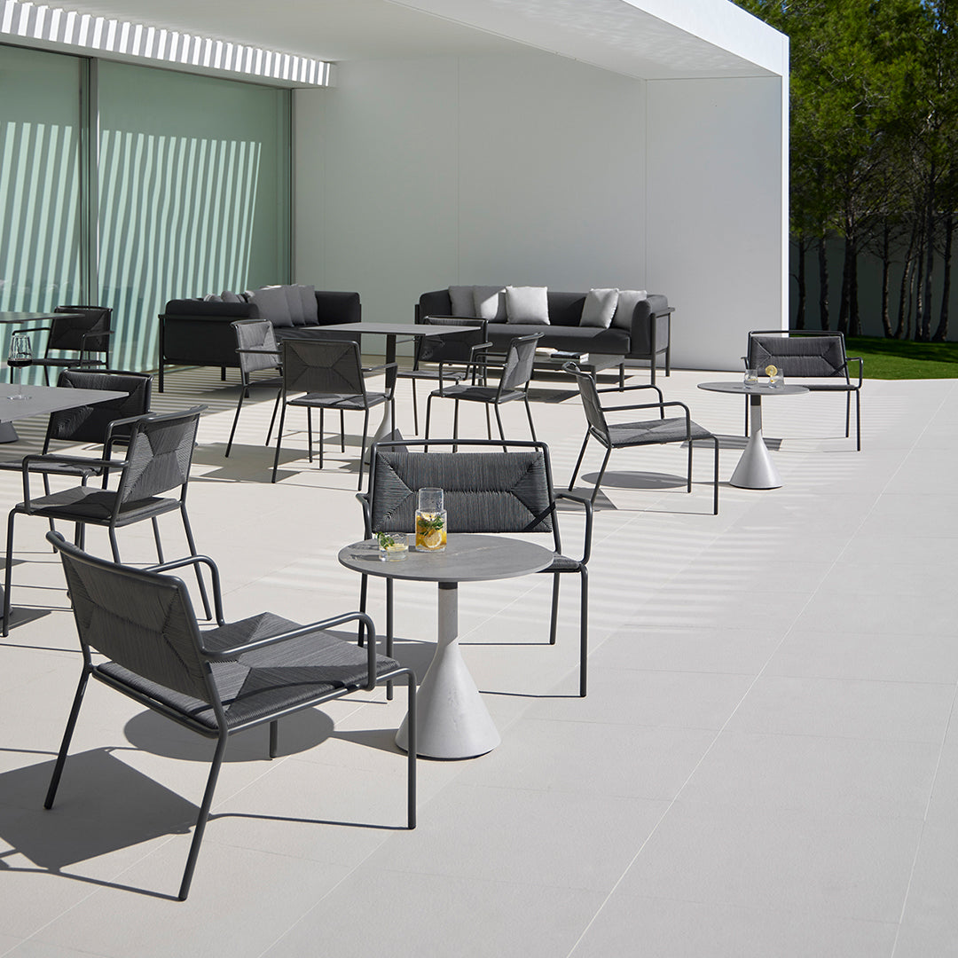 Stylish outdoor seating featuring sleek gray chairs and tables on a minimalist white patio. Perfect for modern spaces.