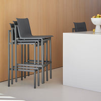 Stacked gray chairs against a light wooden wall, featuring a modern minimalist design with clean lines.