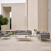 Modern outdoor furniture set in light gray with subtle patterns, featuring sleek lines and a minimalist design.