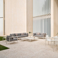 Stylish outdoor seating in gray fabric with light gray aluminum frames, set against a modern, neutral backdrop.