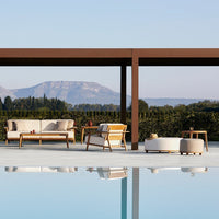 Modern outdoor furniture in neutral tones with soft textures, set against a serene natural backdrop.