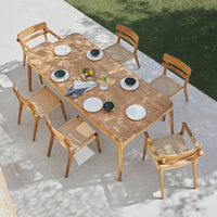 Light natural wood dining table with six woven chairs, featuring a minimalist design and neutral color palette.