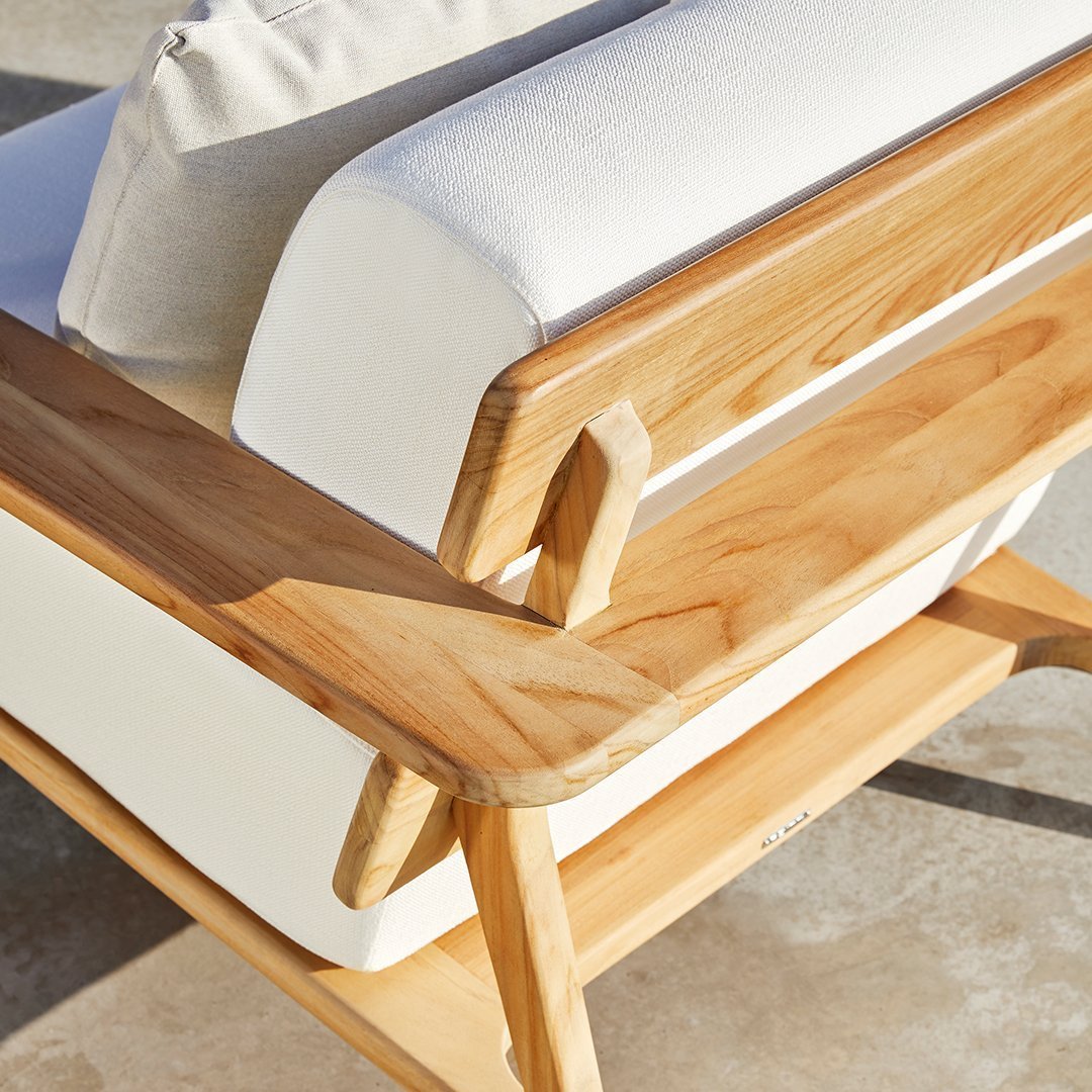 Light wood frame with white cushions, featuring clean lines and a modern design, ideal for outdoor settings.