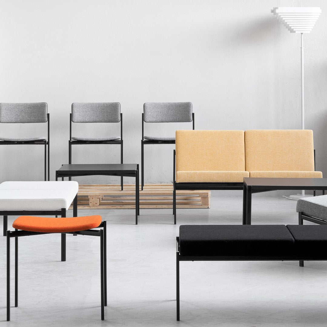Modern seating in gray, yellow, black, white, and orange; minimalist design with sleek patterns and clean lines.