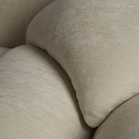 Soft beige throw pillows with subtle texture and smooth curves, perfect for elegant home decor.