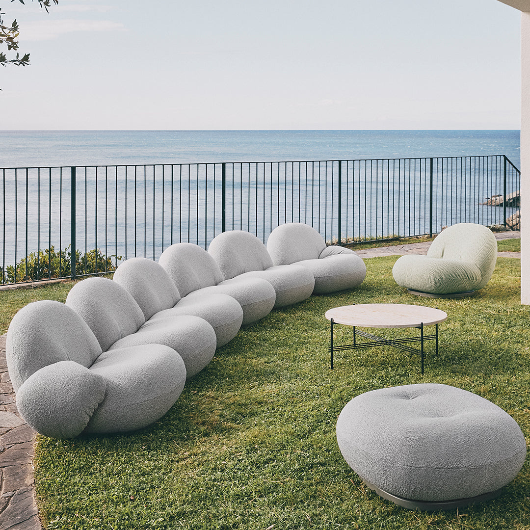 Gray rounded sofa set with soft textures, complemented by a light green accent chair and a circular coffee table.