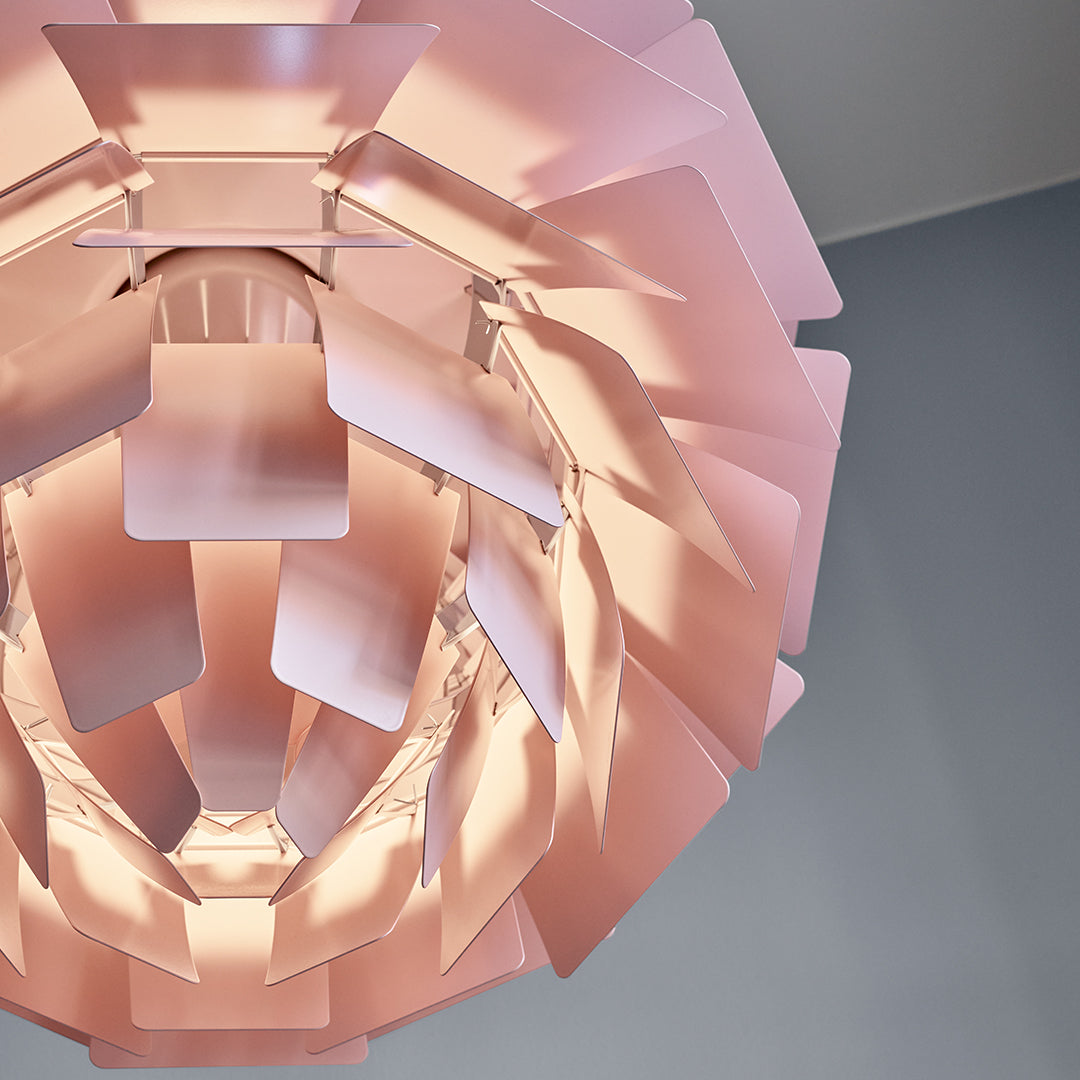 Pink geometric lamp with layered petal-like design against a soft gray background. Elegant and modern aesthetic.