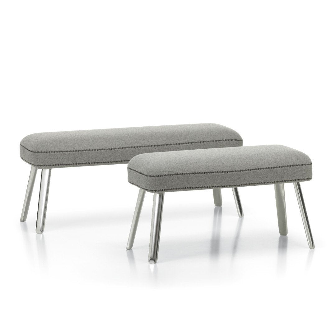 Gray upholstered benches with sleek, light gray legs; minimalist design complements modern decor.