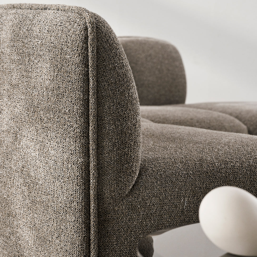 Textured gray upholstery with soft curves and subtle pattern, designed for modern furniture aesthetics.