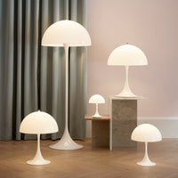 White modern lamps with smooth curves, set against a soft pastel backdrop and elegant gray curtains.