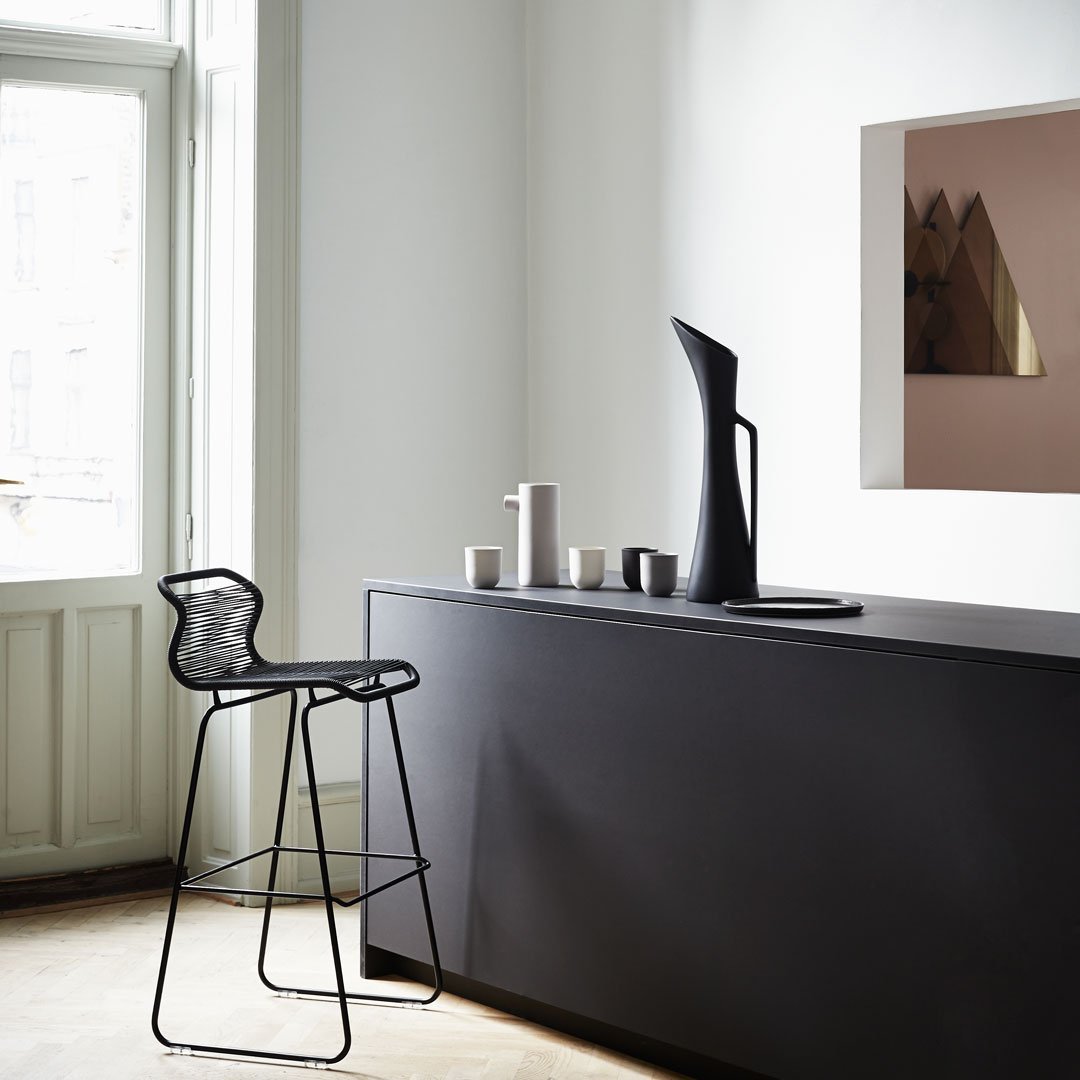 Modern black kitchen bar with sleek lines, featuring geometric patterns and minimalistic decor in neutral tones.