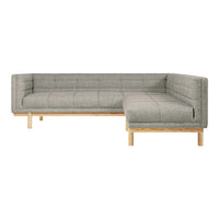 Gray upholstered sectional sofa with a quilted pattern and natural wood legs. Modern, minimalist design for any space.