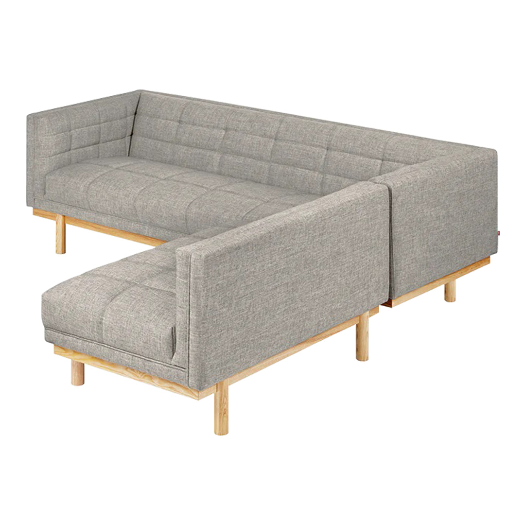 L-shaped sofa in a soft gray fabric with quilted pattern, featuring natural wood legs for a modern touch.