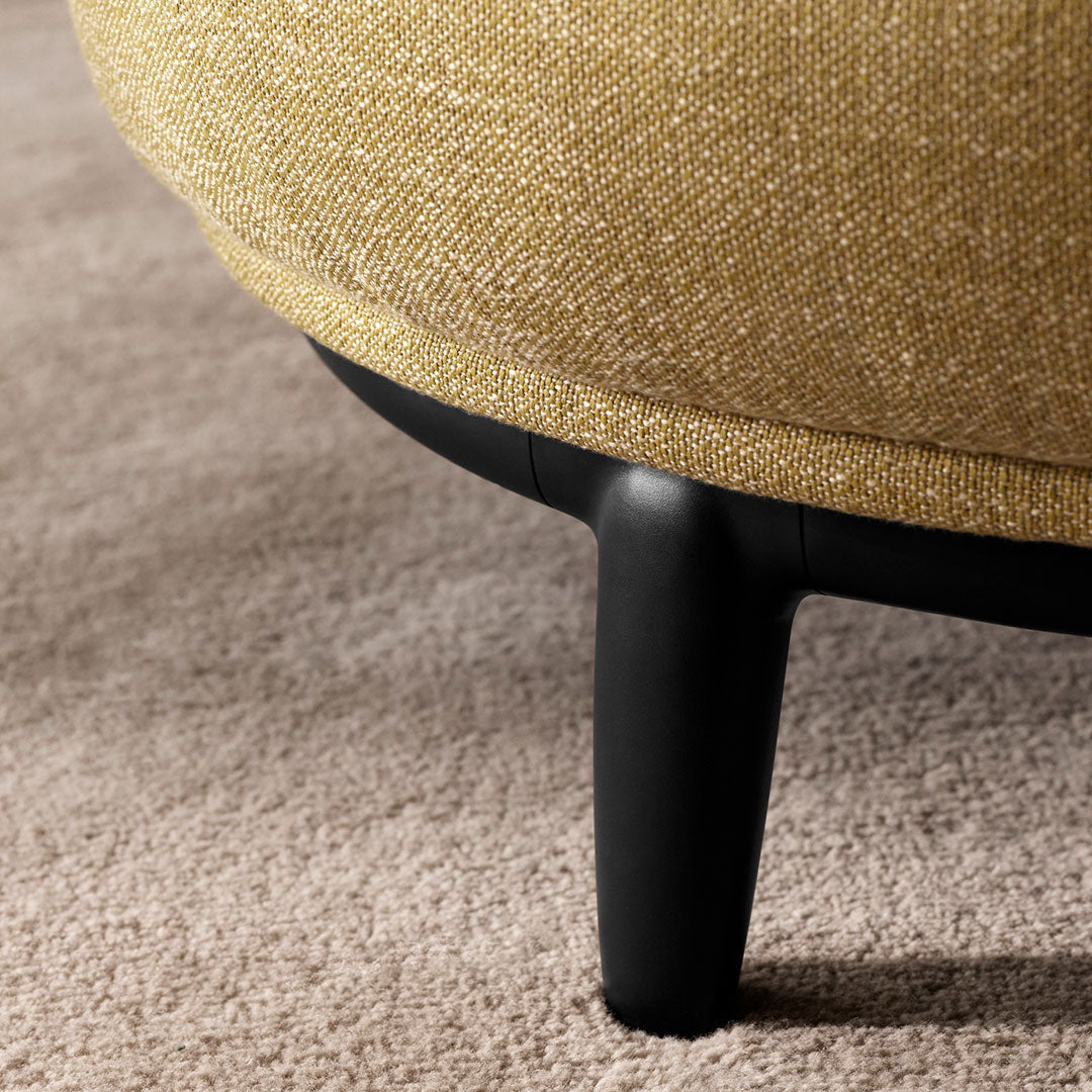 Close-up of a textured mustard yellow fabric with black legs, highlighting the rich color and subtle pattern.