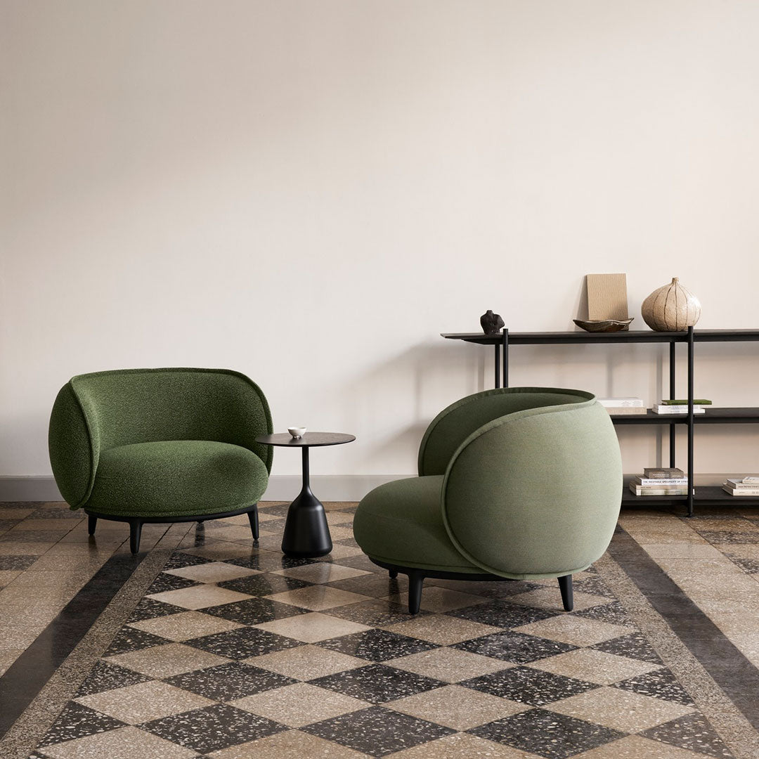Green upholstered chairs on a patterned tile floor, showcasing a modern and cozy interior design aesthetic.