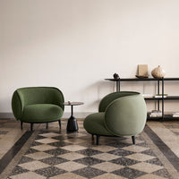 Green upholstered chairs on a patterned tile floor, showcasing a modern and cozy interior design aesthetic.