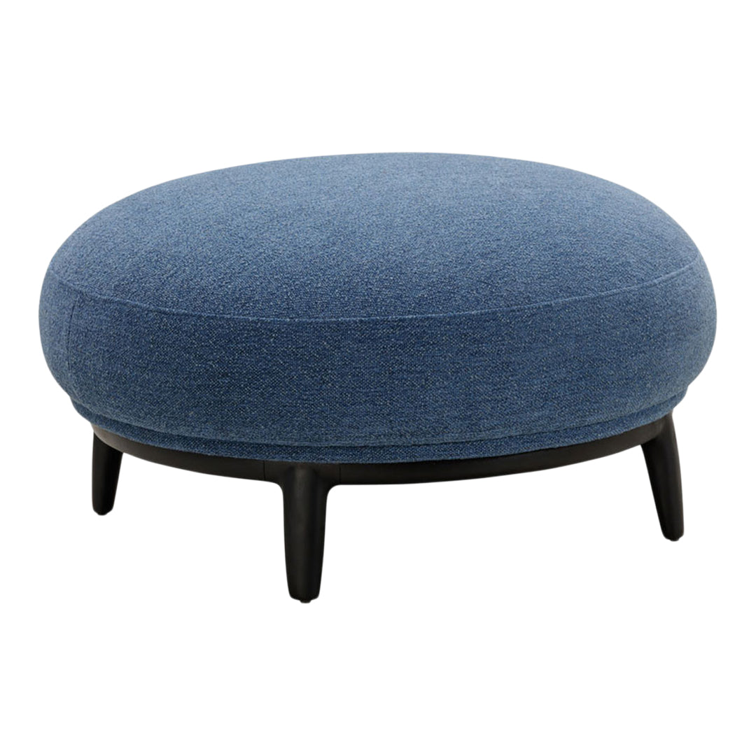 Round denim ottoman with a solid dark base, featuring a soft texture and a rich blue color. Elegant and modern style.