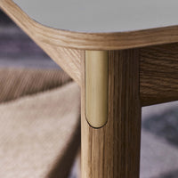 Light wood texture with smooth, curved edges; brass accent detail adds elegance to modern design.