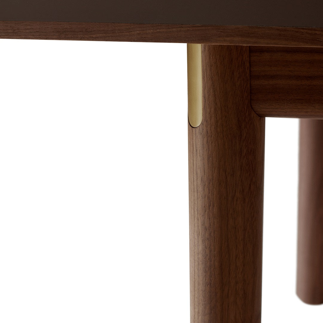 Wooden table legs with a warm walnut finish and subtle gold accents; modern and sleek design.
