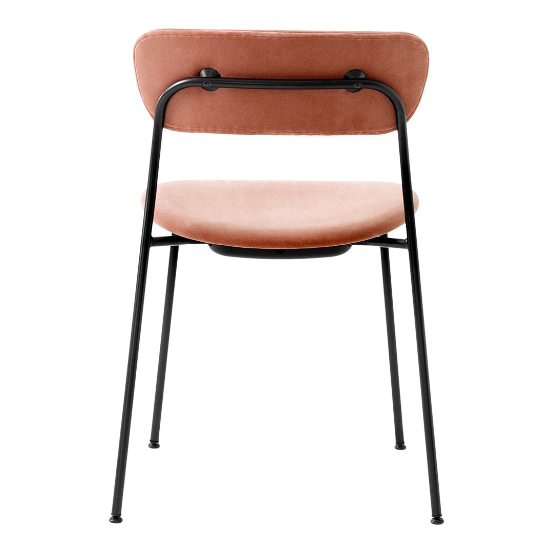 Back view of a pink velvet chair with a black metal frame and minimalist design, showcasing its soft color and sleek lines.