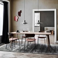 Modern dining room featuring gray walls, a light wood table, pink chairs, and a textured gray rug. Elegant and minimalist design.