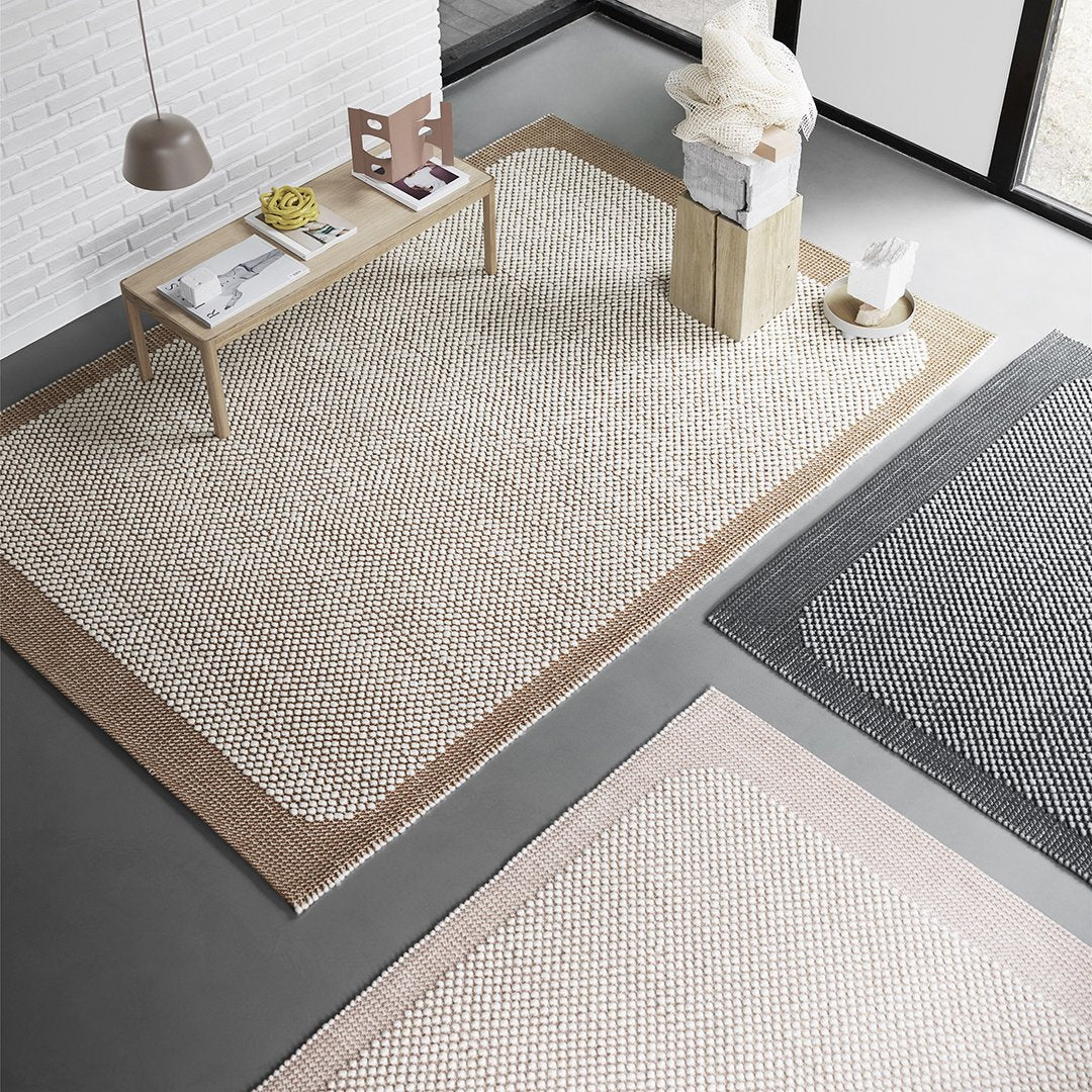 Neutral-toned area rugs featuring textured patterns in beige, gray, and blush pink. Perfect for modern interiors.