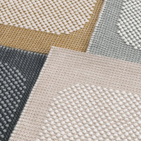 Textured area rug featuring beige, gray, gold, and dark gray colors with circular patterns.