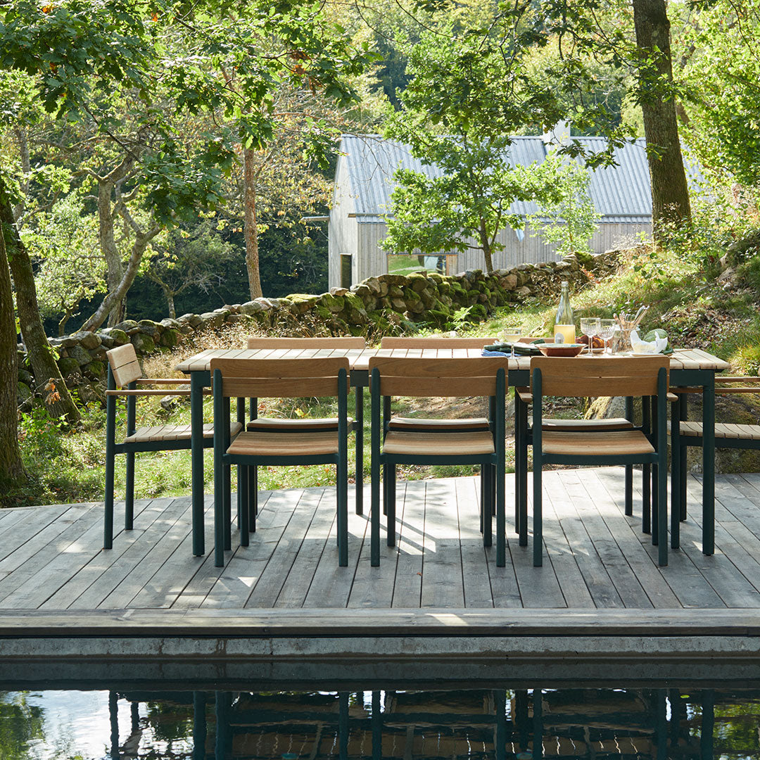 Outdoor dining set with natural wood tones and black accents, featuring a sleek design perfect for patios.