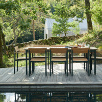 Outdoor dining set with natural wood tones and black accents, featuring a sleek design perfect for patios.