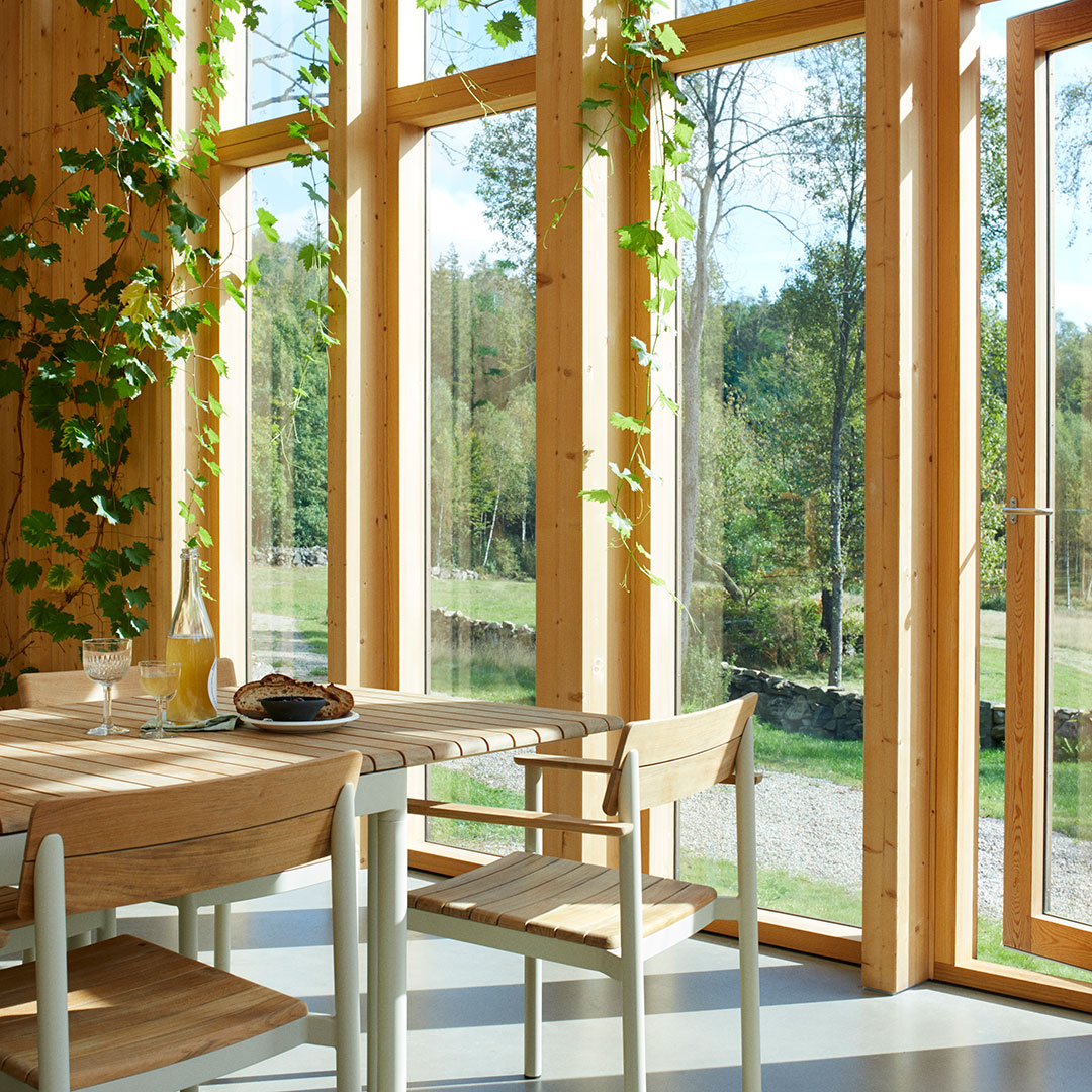 Natural wood tones, green plant accents, and light colors enhance a bright, airy interior space. Ideal for modern decor.