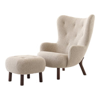 Cream-colored upholstered armchair with tufted details and matching ottoman, set on dark wooden legs.