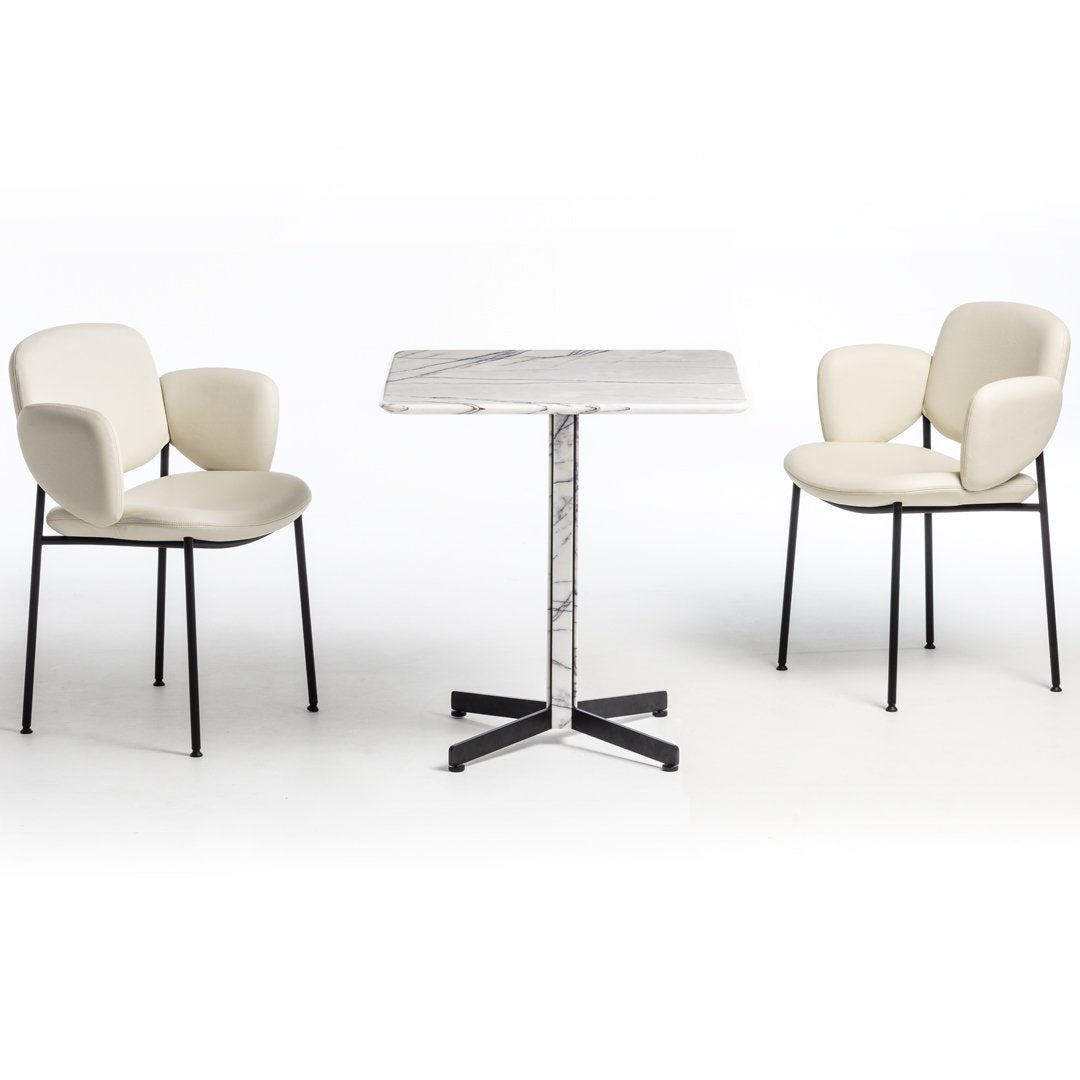 Modern dining set featuring soft cream chairs and a sleek marble-top table with black metal legs.