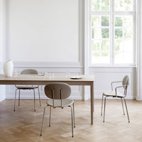 Stylish light gray chairs with minimalist design around a natural wood table in a bright, airy room.