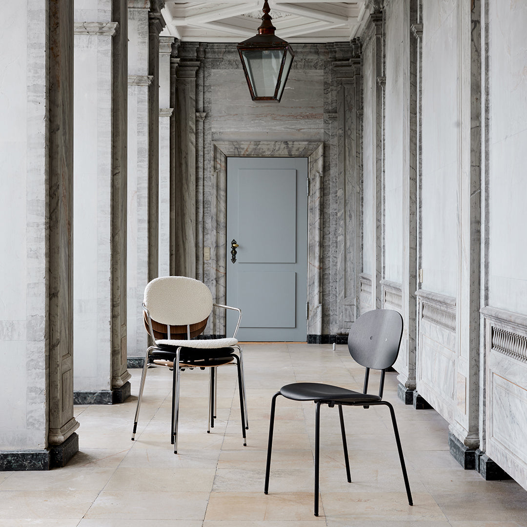 Two stylish chairs in black and cream, showcasing sleek designs against a neutral-toned elegant backdrop.