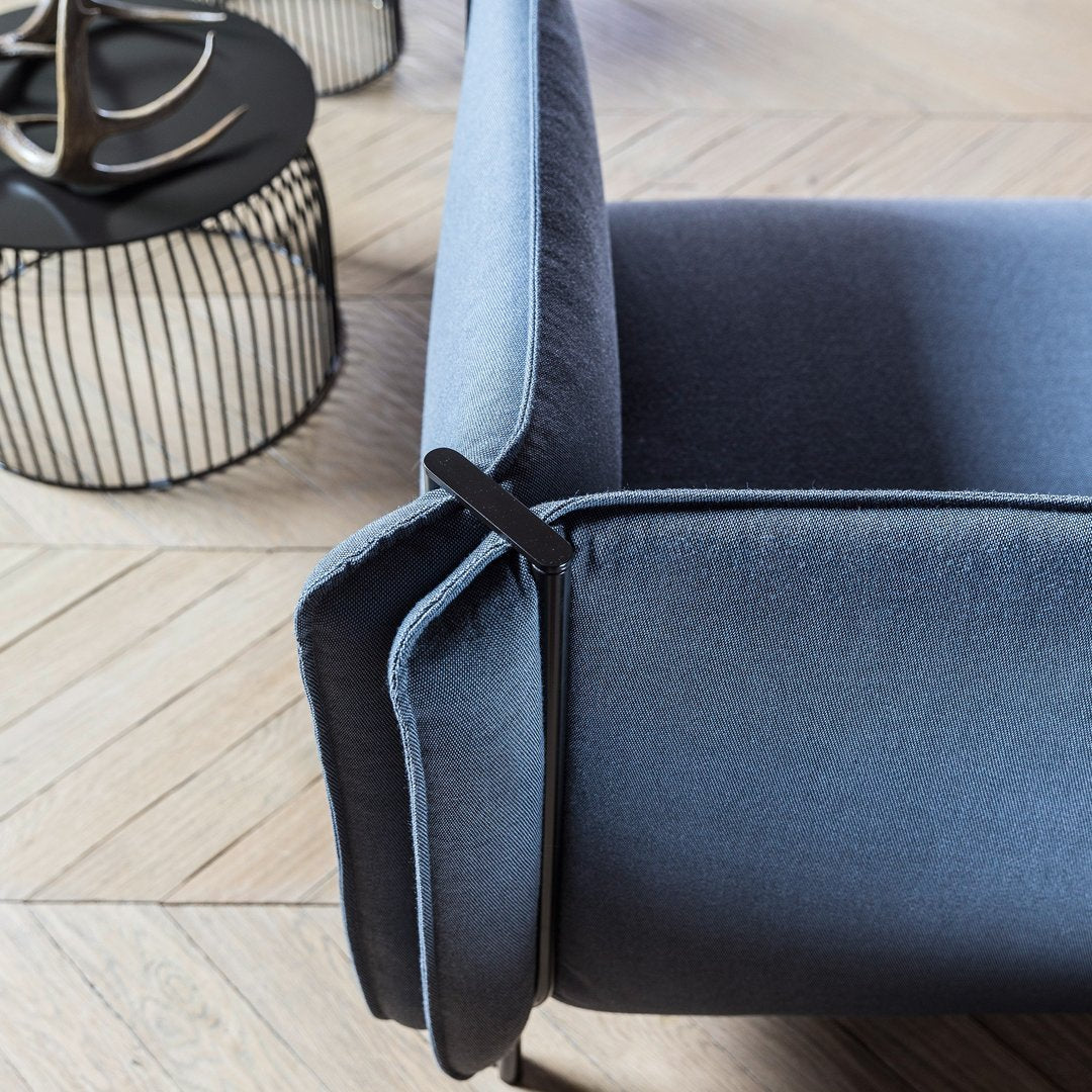 Close-up of a modern sofa showcasing a gradient of deep navy to light blue upholstery with sleek, minimalistic lines.