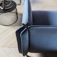 Close-up of a modern sofa showcasing a gradient of deep navy to light blue upholstery with sleek, minimalistic lines.