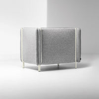 Gray upholstered couch with subtle texture and contrasting white piping on metal legs, creating a modern look.