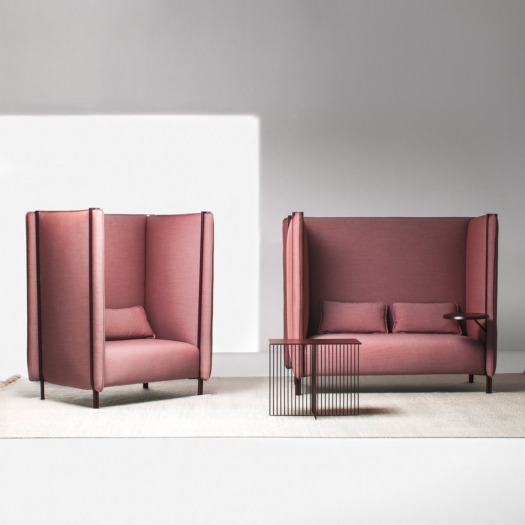 Pink fabric upholstery sofas with unique high-back designs, complemented by sleek black metal legs. Modern and stylish.