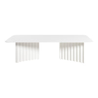 White modern dining table with sleek, smooth surface and textured, ribbed legs for a minimalist design.