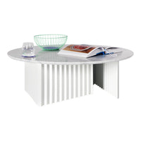 Round white marble coffee table with elegant ribbed white base and vibrant green wire bowl. Modern and stylish design.