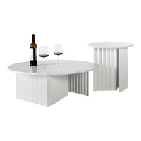 Elegant round marble tabletop with vertical white ribbed base, complemented by two wine glasses and a bottle.