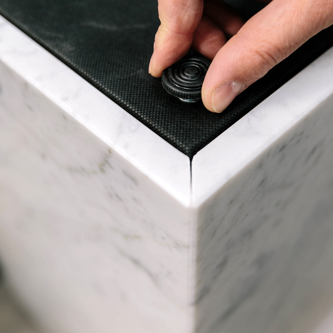 Close-up of a black textured surface on top of a sleek, white marble base, showcasing elegant color contrast and patterns.