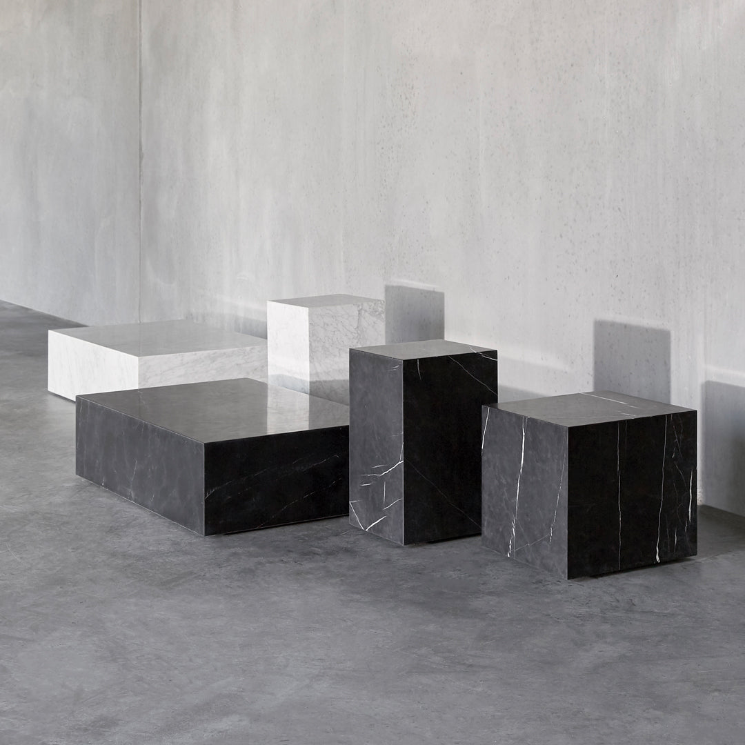 Modern geometric blocks in black and white marble with sleek, minimalist patterns on a textured gray background.