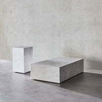 Minimalist concrete coffee tables in smooth gray finish, showcasing clean lines and geometric shapes.