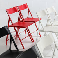 Red, black, and white folding chairs with a sleek, modern design and minimalist patterns.
