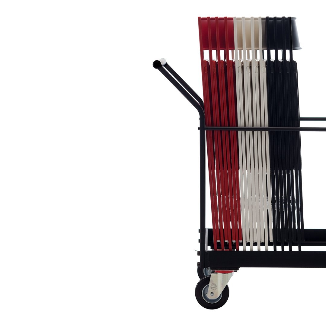 "Stack of red, black, and white folders in a cart with sleek black metal frame, showcasing bold colors and clean lines."