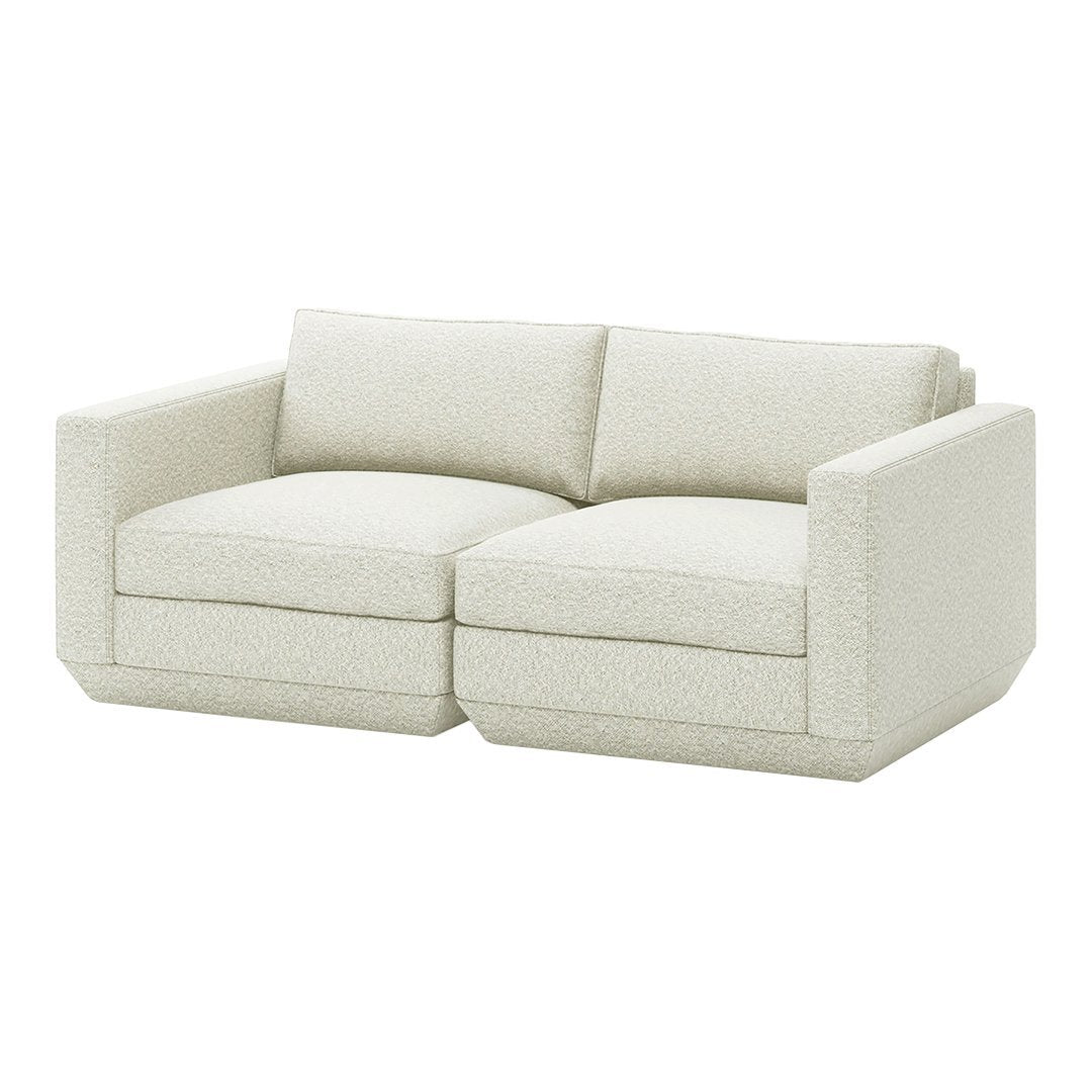Light beige upholstered loveseat with subtle textured pattern and modern, boxy design. Perfect for contemporary interiors.