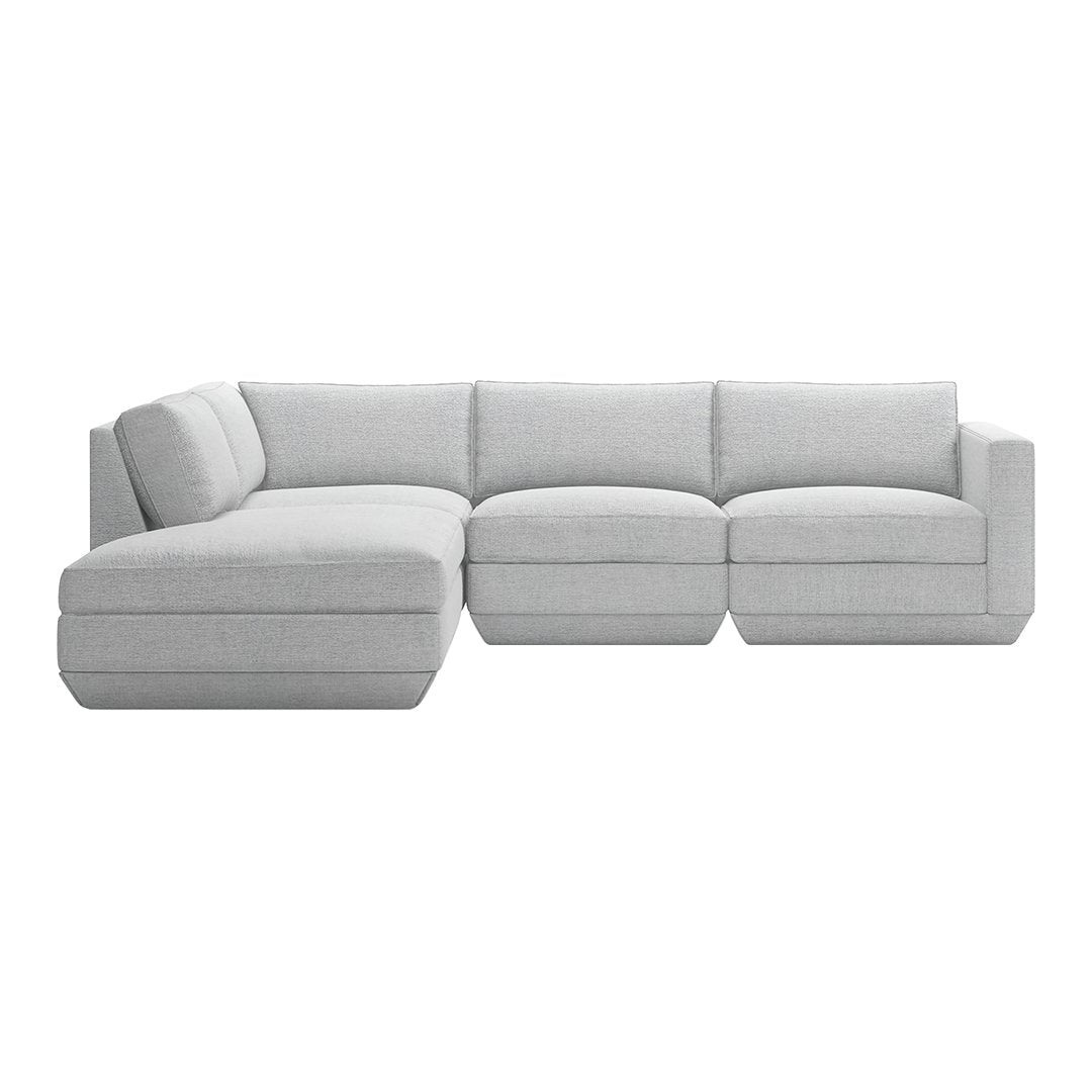L-shaped sectional sofa in soft light gray fabric with seamless, minimalist design and plush cushions.